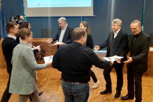 Die Teilnehmer der vierten Bürgerversammlung überreichen ihre 22 Empfehlungen (Bild: Manuel Zimmermann/BRF)