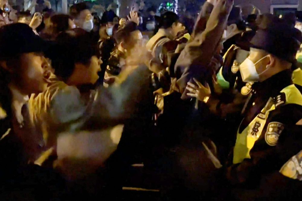 Dieser Ausschnitt aus einem Augenzeugenvideo zeigt Demonstranten, die in Shanghai Parolen rufen, während die Polizei sie festhält (Bild: AFP TV/AFP)