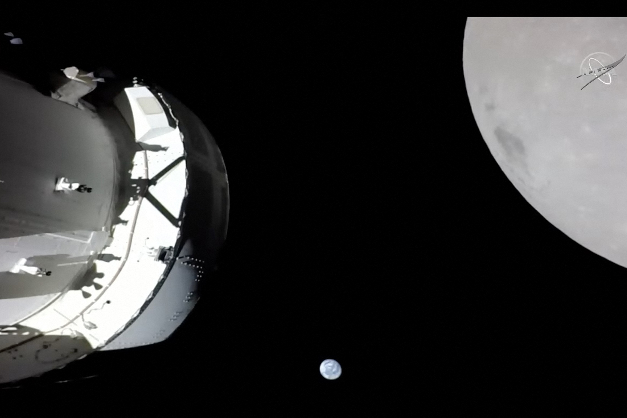 Die Raumkapsel, die Erde und der Mond, aufgenommen von einer Kamera auf dem Solar-Array-Flügel von Orion (Bild: Handout/NasaTV/AFP)