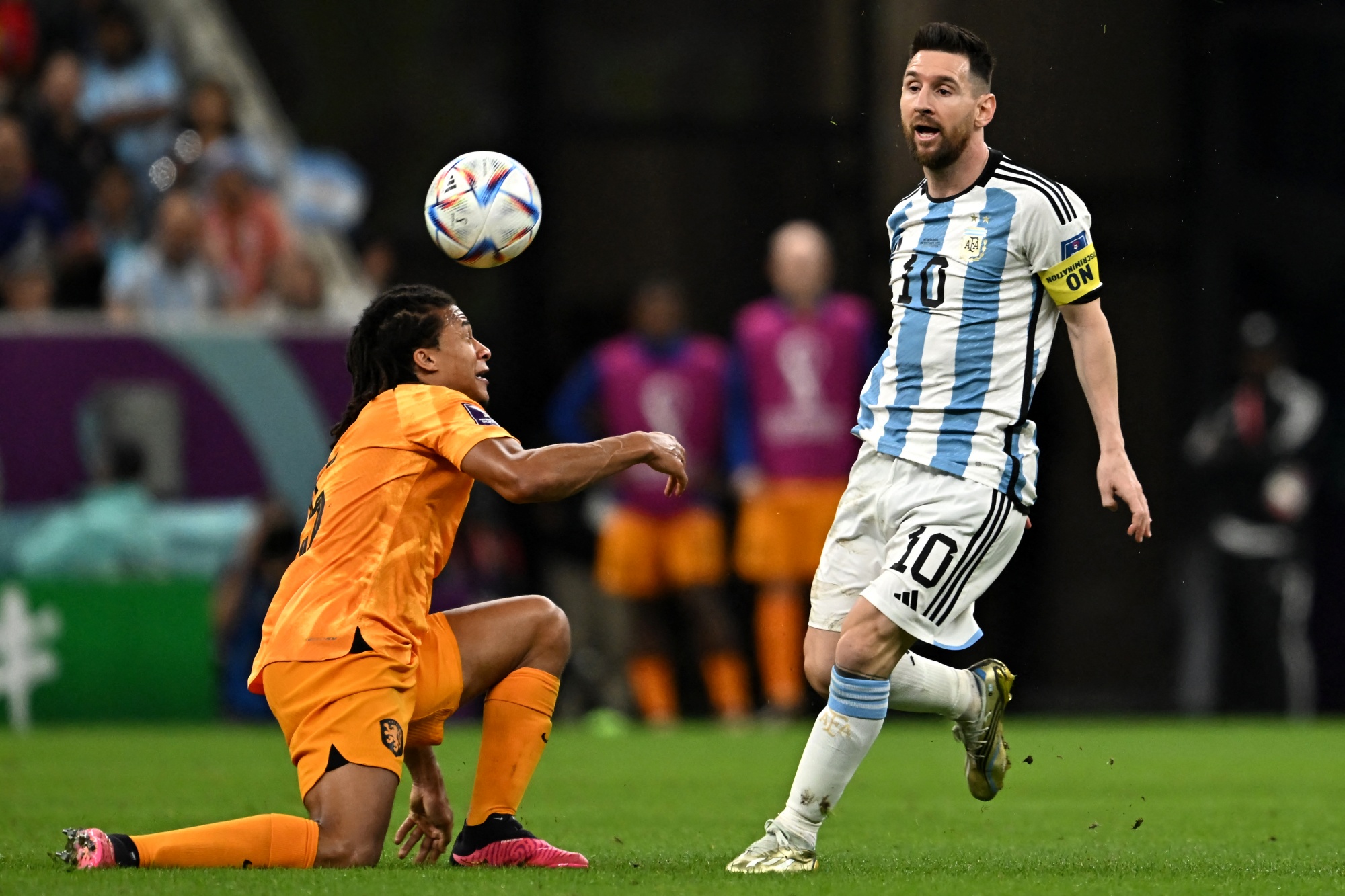 Netherlands' defender #05 Nathan Ake and Argentina's forward #10 Lionel Messi fight for the ball during the Qatar 2022 World Cup quarter-final football match between Netherlands and Argentina at Lusail Stadium, north of Doha, on December 9, 2022. (Photo by MANAN VATSYAYANA / AFP)