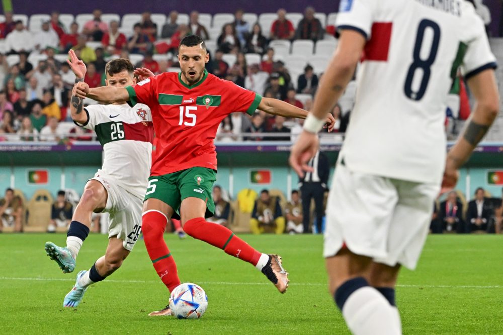 Portugal's midfielder #25 Otavio fights for the ball with Morocco's midfielder #15 Selim Amallah during the Qatar 2022 World Cup quarter-final football match between Morocco and Portugal at the Al-Thumama Stadium in Doha on December 10, 2022. (Photo by Alberto PIZZOLI / AFP)