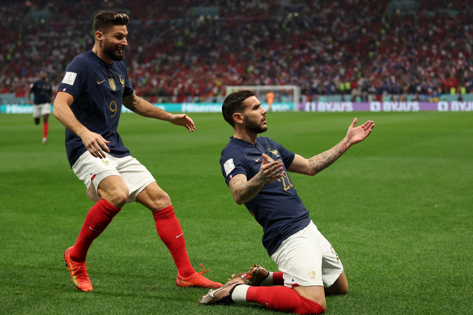 France's defender #22 Theo Hernandez celebrates with France's forward #09 Olivier Giroud after scoring his team's first goal during the Qatar 2022 World Cup semi-final football match between France and Morocco at the Al-Bayt Stadium in Al Khor, north of Doha on December 14, 2022. (Photo by Adrian DENNIS / AFP)