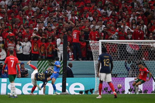 France's defender #22 Theo Hernandez (L) scores his team's first goal during the Qatar 2022 World Cup semi-final football match between France and Morocco at the Al-Bayt Stadium in Al Khor, north of Doha on December 14, 2022. (Photo by Kirill KUDRYAVTSEV / AFP)