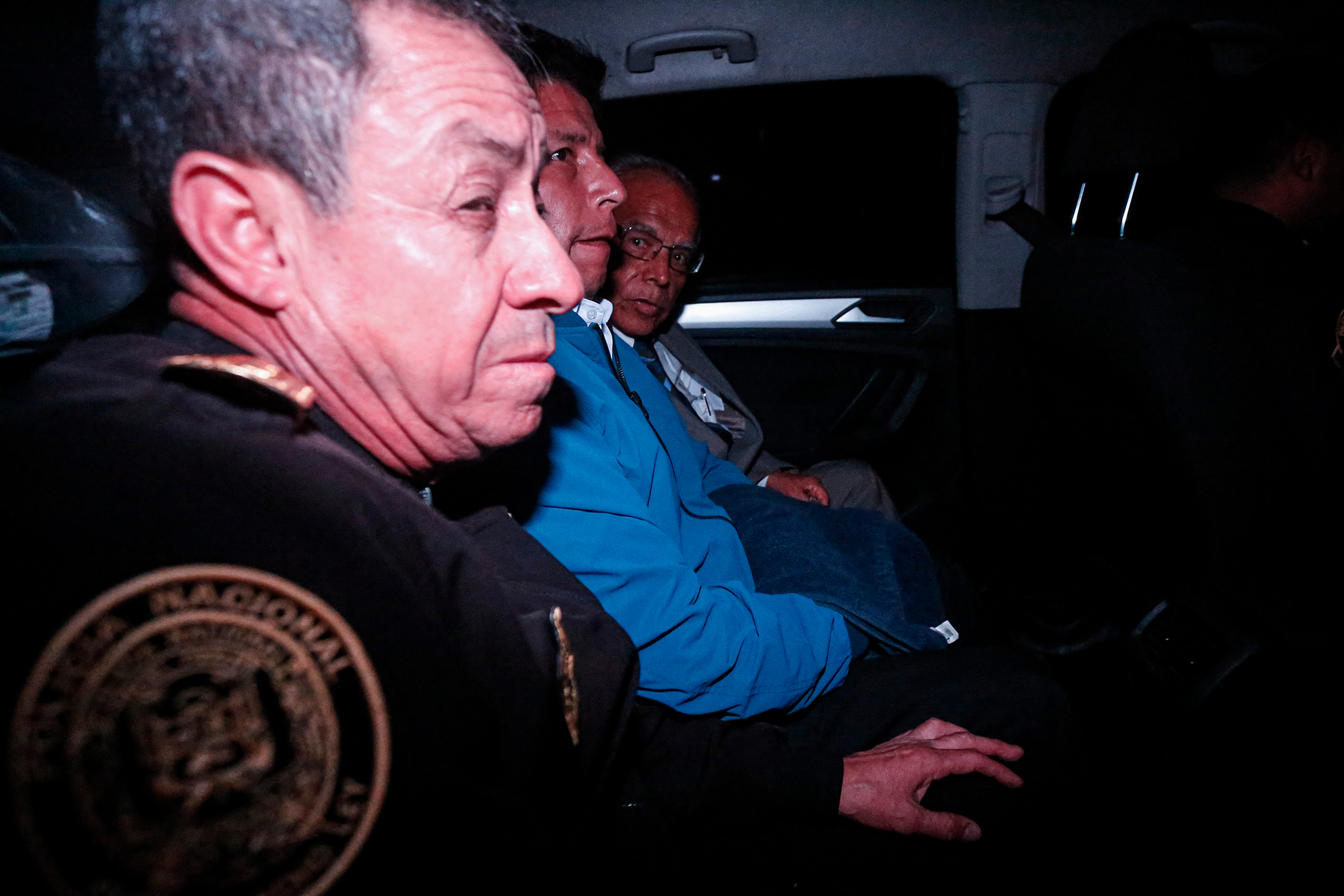 Perus bisheriger Präsident Pedro Castillo (Mi.) in einem Polizeiauto (Bild: Renato Pajuelo/AFP)
