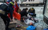 Rettungskräfte helfen einer verletzten Frau in Cherson am 24.12.2022 (Bild: Dimitar Dilkoff/AFP)