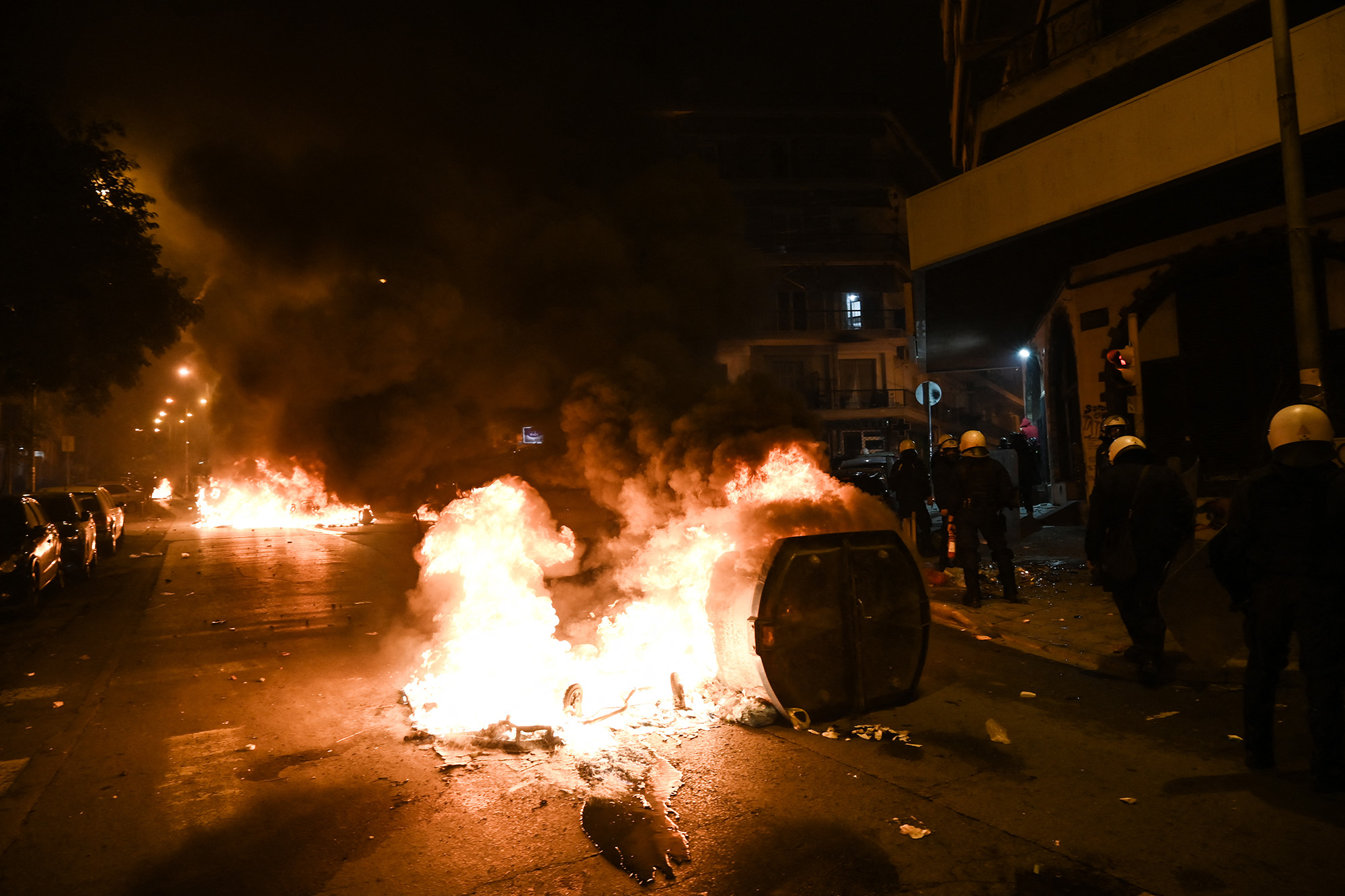 Von Demonstranten errichtete Straßensperren brennen bei Zusammenstößen am Rande einer Kundgebung gegen Polizeigewalt am Abend des 6. Dezember (Bild: Sakis Mitrolidis/AFP)