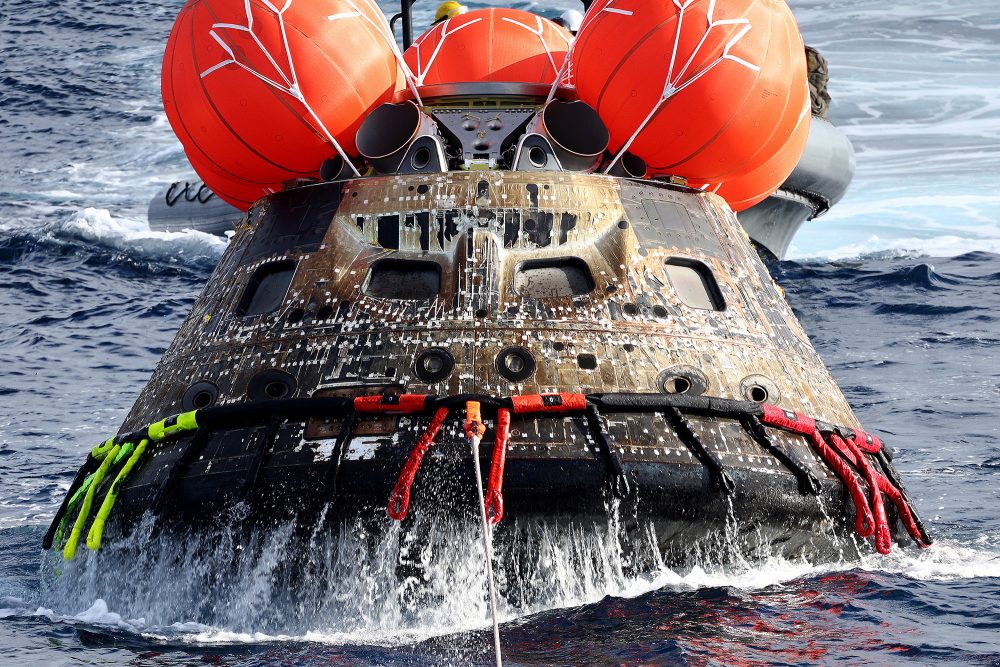 Die Orion-Kapsel der Nasa wird nach der Artemis-1-Mondmission auf das Wellendeck der USS Portland gezogen, nachdem sie im Pazifischen Ozean vor der Küste Mexikos gelandet ist (Bild: Mario Tama/Pool/AFP)