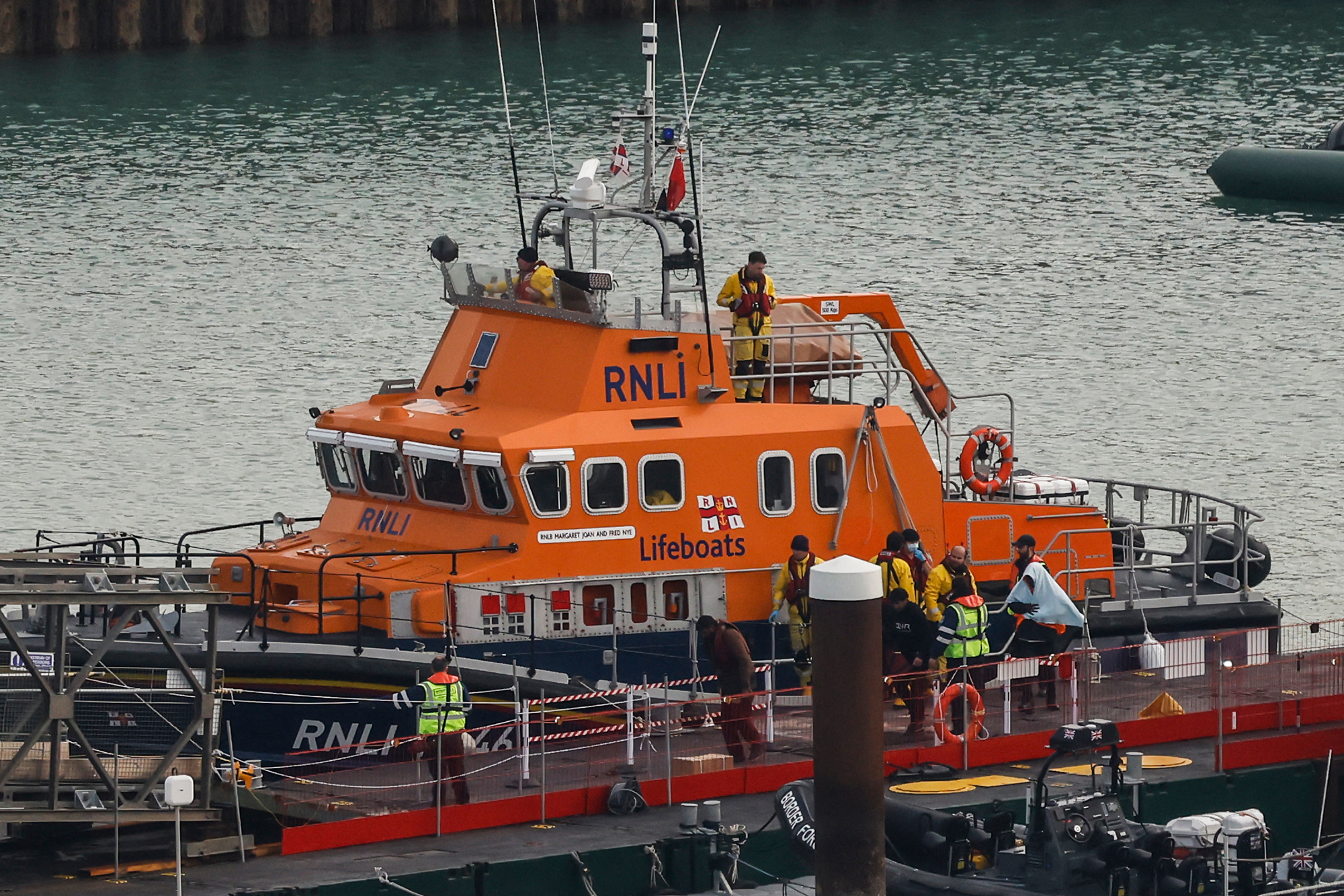 Migranten, die bei dem Versuch, den Ärmelkanal zu überqueren, auf See aufgegriffen wurden, werden vom Rettungsboot der britischen Royal National Lifeboat Institution (RNLI) im Hafen von Dover im Südosten Englands eskortiert (Bild: Carlos Jasso/AFP)