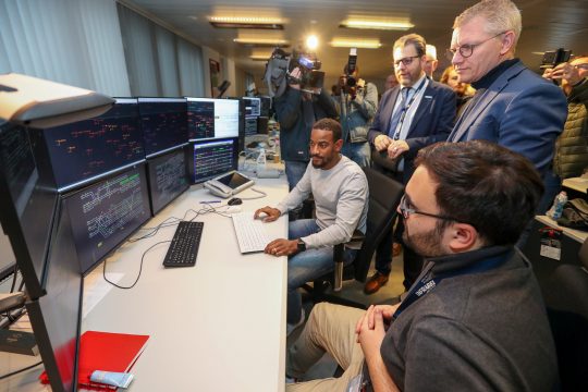 Mobilitätsminister Georges Gilkinet (re.) und Infrabel-CEO Benoit Gilson (Mi.) bei einem Besuch im Brüsseler Stellwerk (Bild: Nicolas Maeterlinck/Belga)