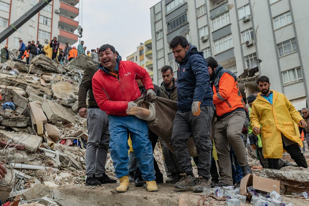 Helfer bergen eine Leiche aus dem Trümmern eines Hauses im türkischen Adana (Bild: Can Erok/AFP)