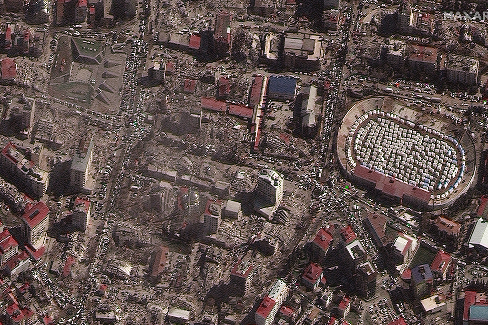 Das Satellitenbild zeigt zerstörte Gebäude sowie Notunterkünfte in einem Stadion in der südtürkischen Stadt Kahramanmaras (Bild: AFP Photo/Satellite image ©2023 Maxar Technologies)