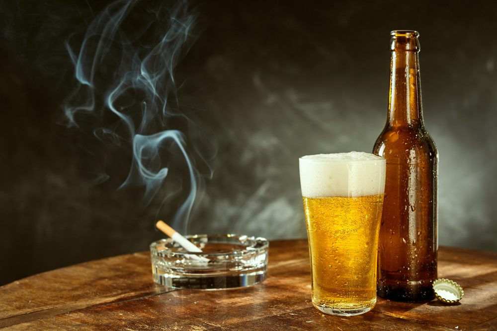 Zigarette im Aschenbecher und ein Bier in der Kneipe