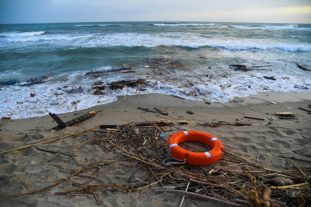 Rettungsring und Trümmer eines Boots am Strand