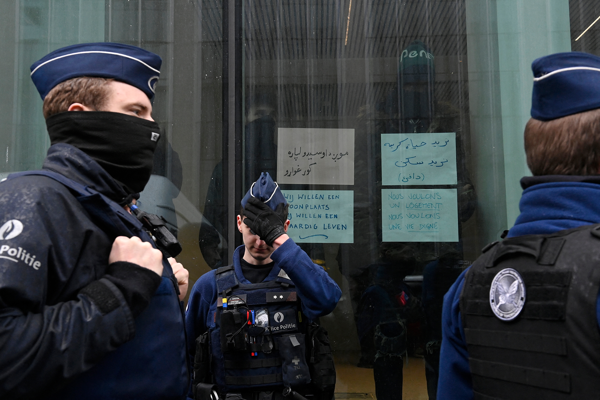 Polizisten vor dem besetzten Gebäude (Bild: John Thys/AFP)