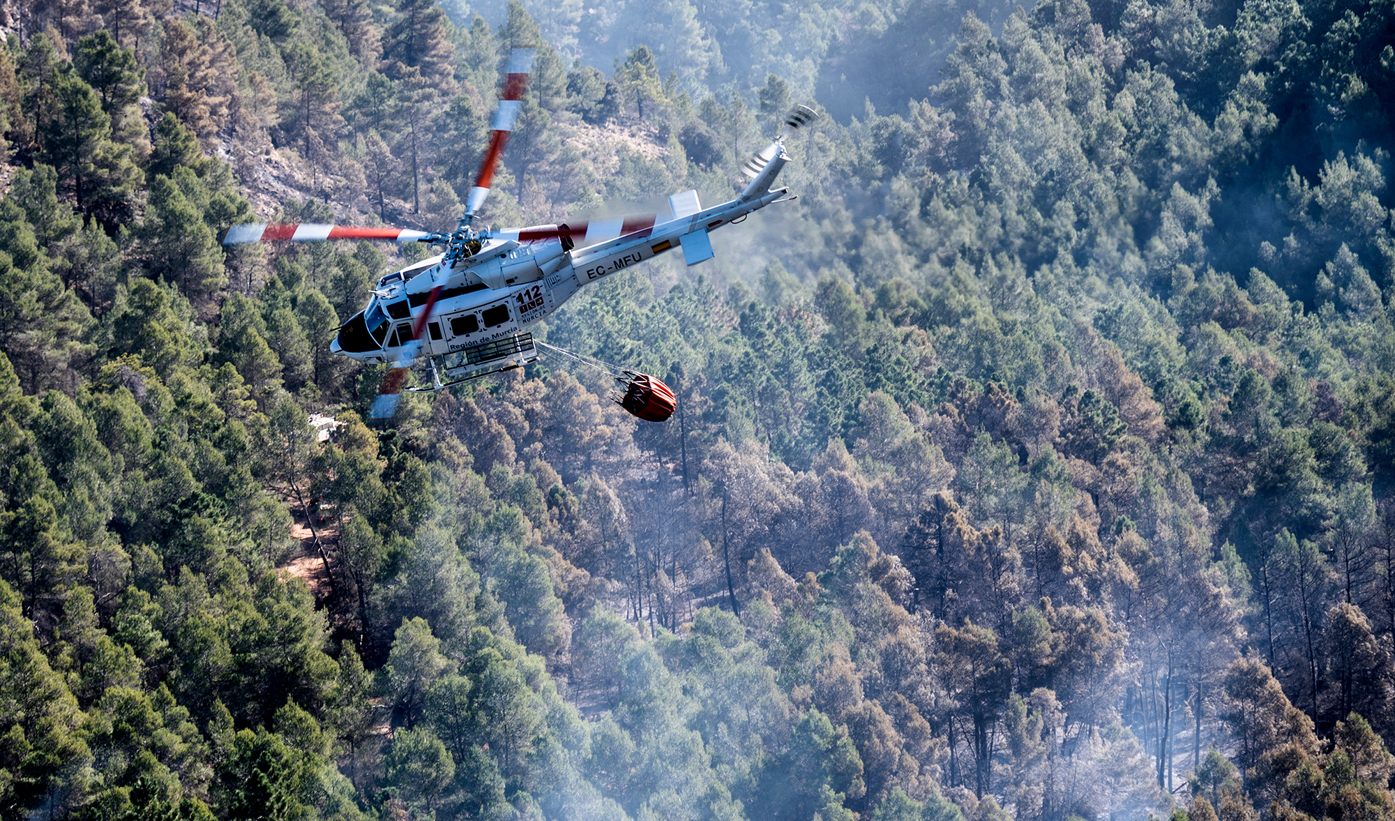 Hubschrauber beim Löschen des Waldbrands in der Nähe des spanischen Dorfes Los Peiros (Bild: Jose Jordan/AFP)