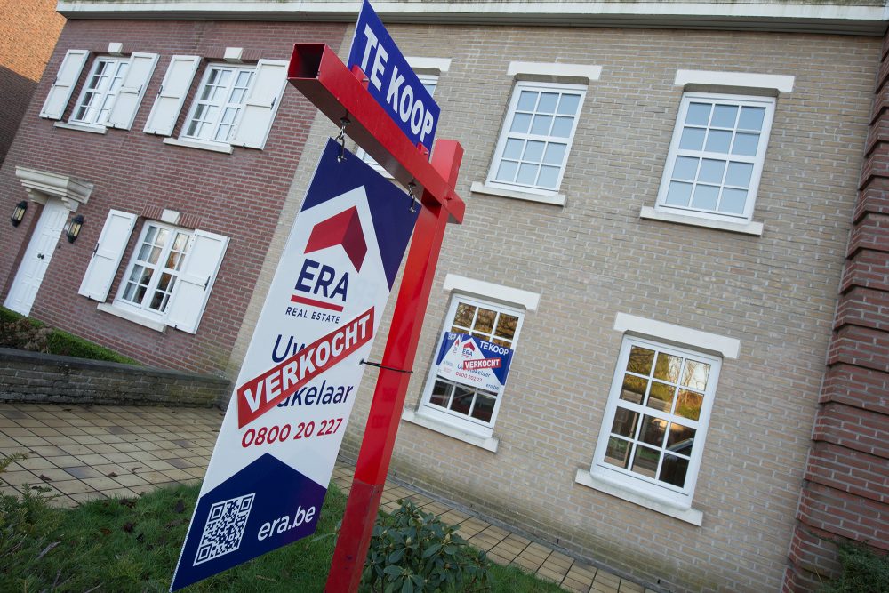 "Verkauft"-Schild eines Immobilienmaklers vor einem Haus
