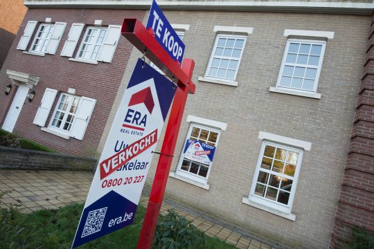 "Verkauft"-Schild eines Immobilienmaklers vor einem Haus