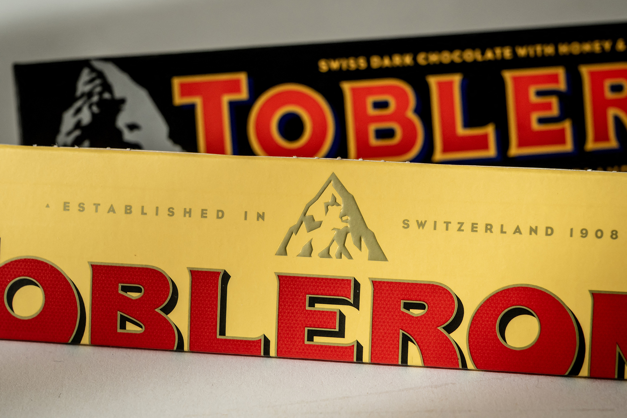 Die "alte" Toblerone-Verpackung mit Matterhorn (hinten) und die neue Verpackung mit dem neuen Logo, das einen "normalen" Berg zeigt (Bild: Fabrice Coffrini/AFP)