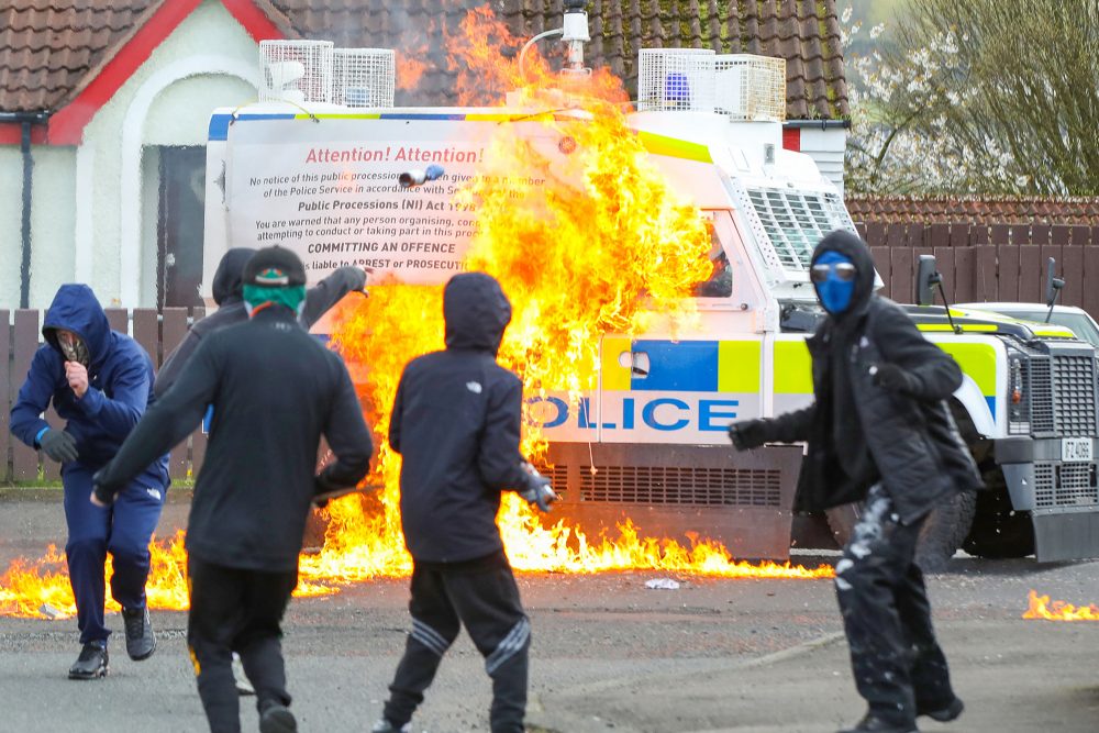 Maskierte Randalierer greifen einen Einsatzwagen der Polizei mit Brandsätzen an, nachdem Republikaner an einem Marsch zum Gedenken an den Osteraufstand von 1916 im Stadtteil Creggan von Londonderry in Nordirland teilgenommen haben (Bild: Paul Faith/AFP)