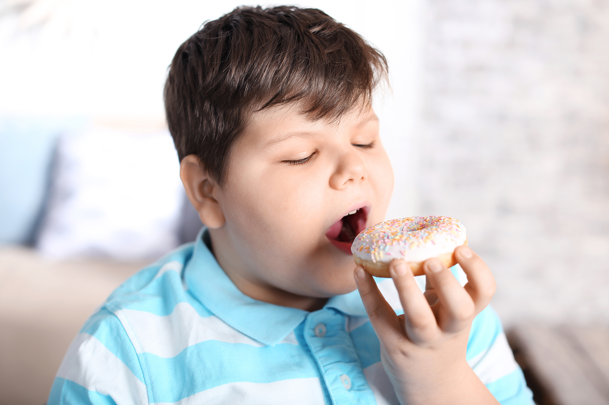 Fettleibiger Junge mit Donut