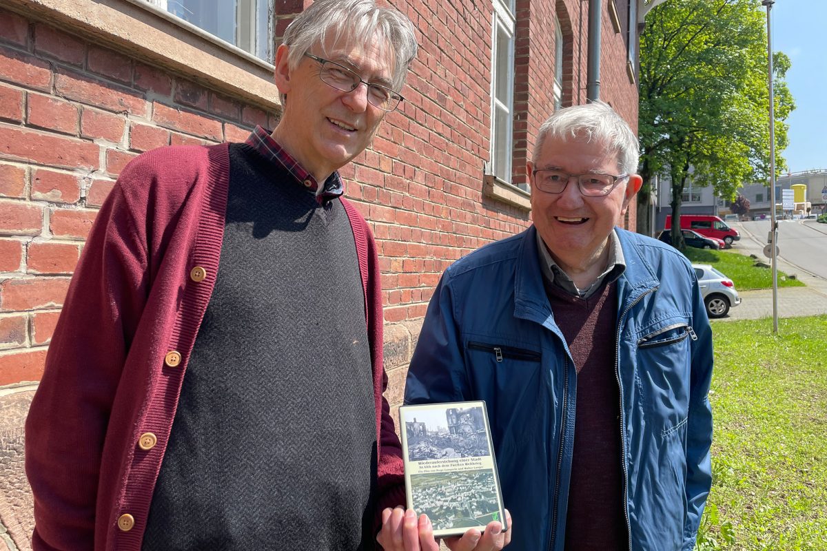 Hugo Lampertz und Hugo Lampertz und Walter Langer mit der DVD "Wiederauferstehung einer Stadt" (Bild: Raffaela Schaus/BRF)