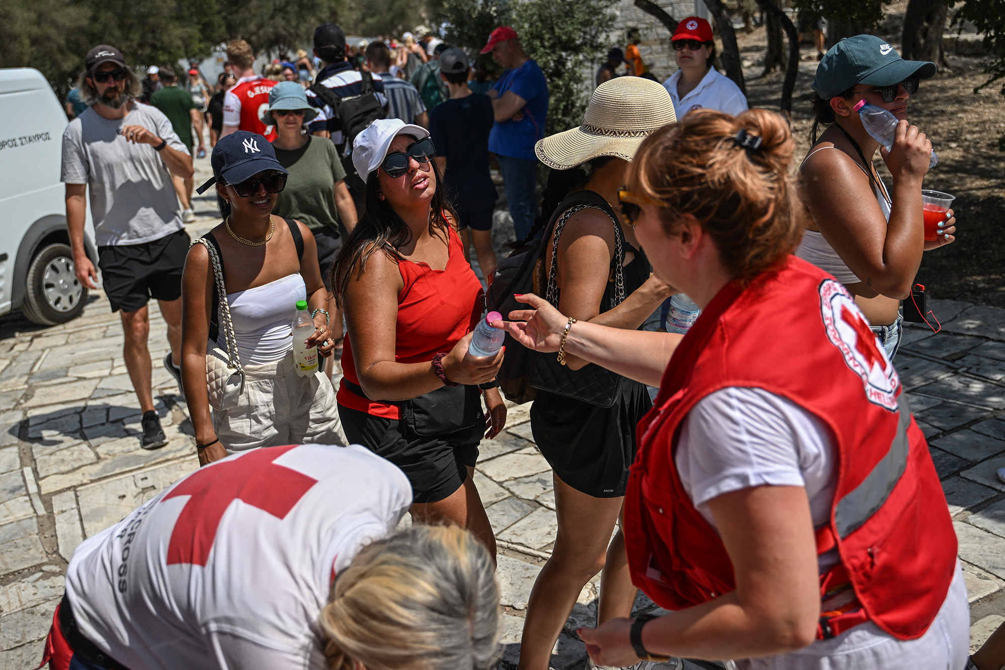 Griechische Rotkreuz-Mitarbeiter verteilen Wasser an Touristen an der Akropolis (Bild: Aris Messinis/AFP)