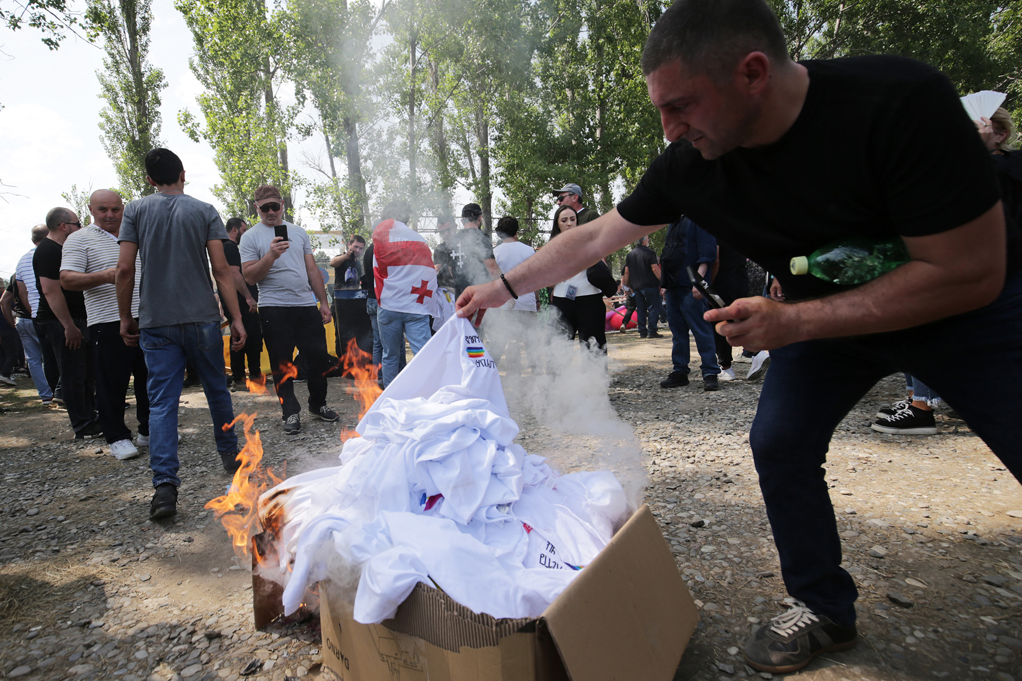Homophober Demonstrant verbrennt T-Shirts mit Regenbogenflagge in Tiflis (Bild: Stringer/AFP)
