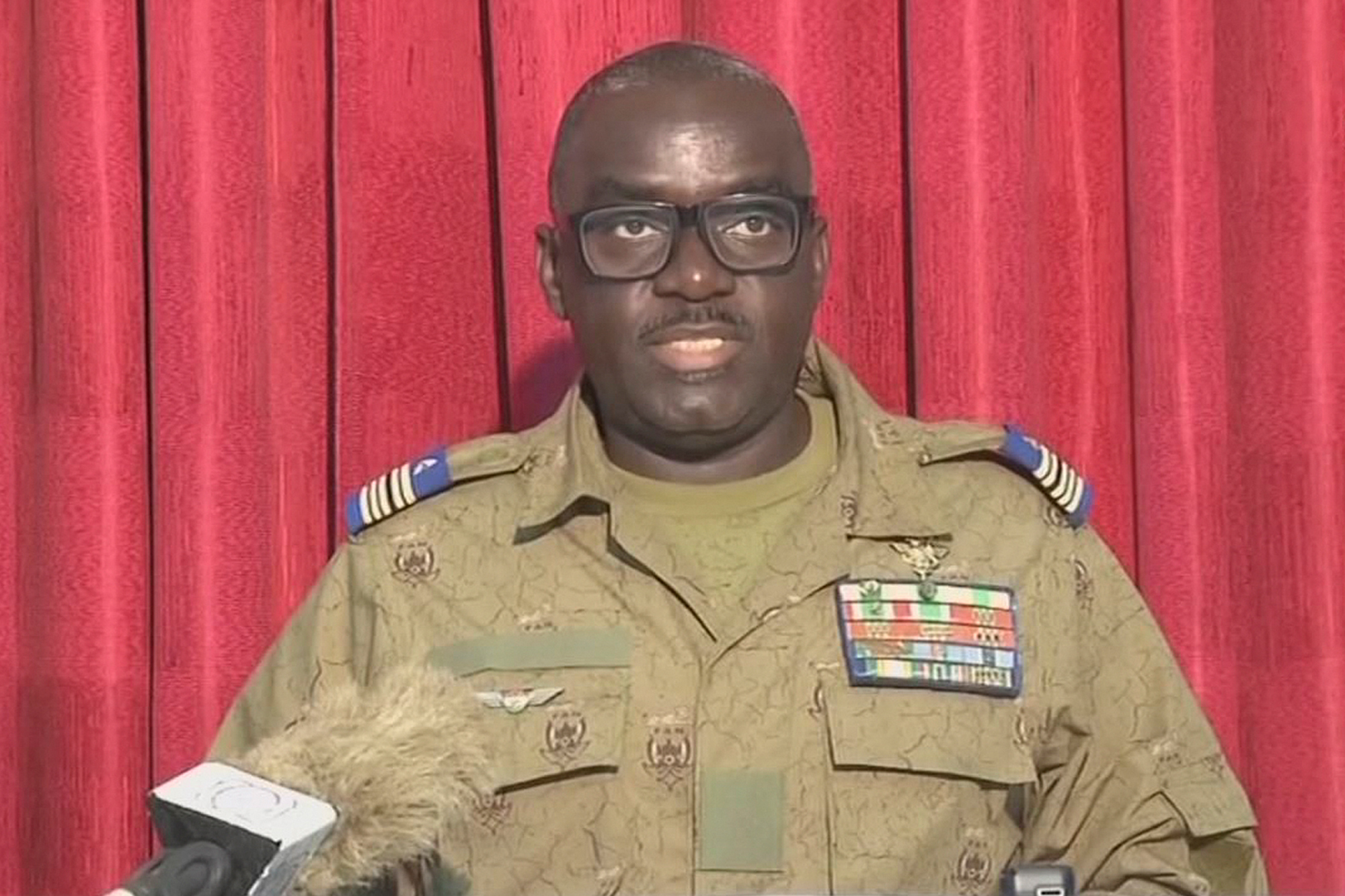Oberst Amadou Abdramane, ein Mitglied des "Conseil national pour la sauvegarde de la patrie" bei der Verlesung einer Erklärung im nationalen Fernsehen (Bild: ORTN/Télé Sahel/AFP)