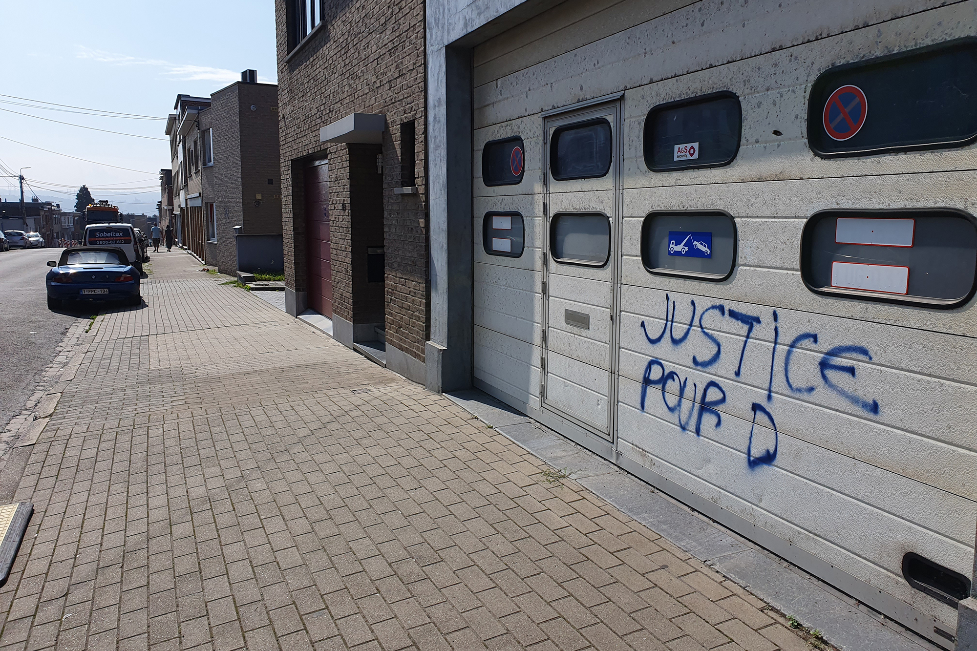 "Justice pour D" steht auf einem Rolltor in Herstal (Bild: Laurent Cavenati/Belga)