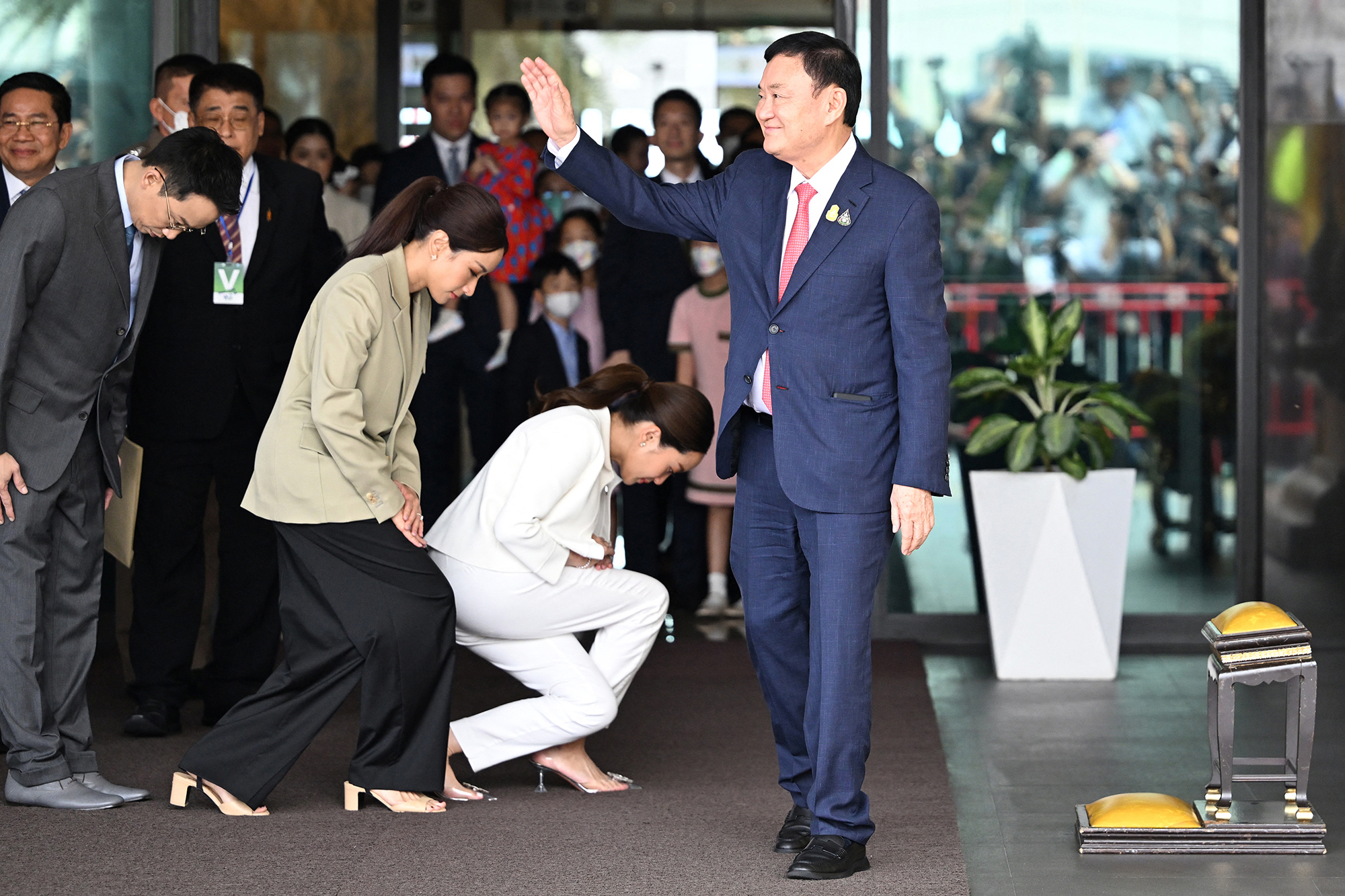 Der ehemalige thailändische Premierminister Thaksin Shinawatra begrüßt seine Anhänger nach der Landung auf dem Flughafen Don Mueang in Bangkok (Bild: Manan Vatsysysna/AFP)