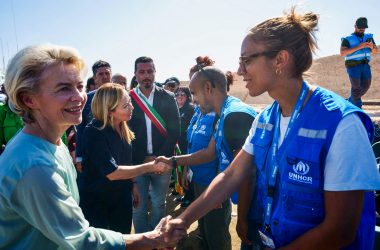 EU-Kommissionspräsidentin Ursula von der Leyen (l.), und Italiens Ministerpräsidentin Giorgia Meloni (2.v.l.) bei der Begrüßung von Mitgliedern des Hohen Flüchtlingskommissars der Vereinten Nationen (UNHCR) während ihres Besuchs auf der italienischen Insel Lampedusa (Bild: Handout/ANSA/AFP)