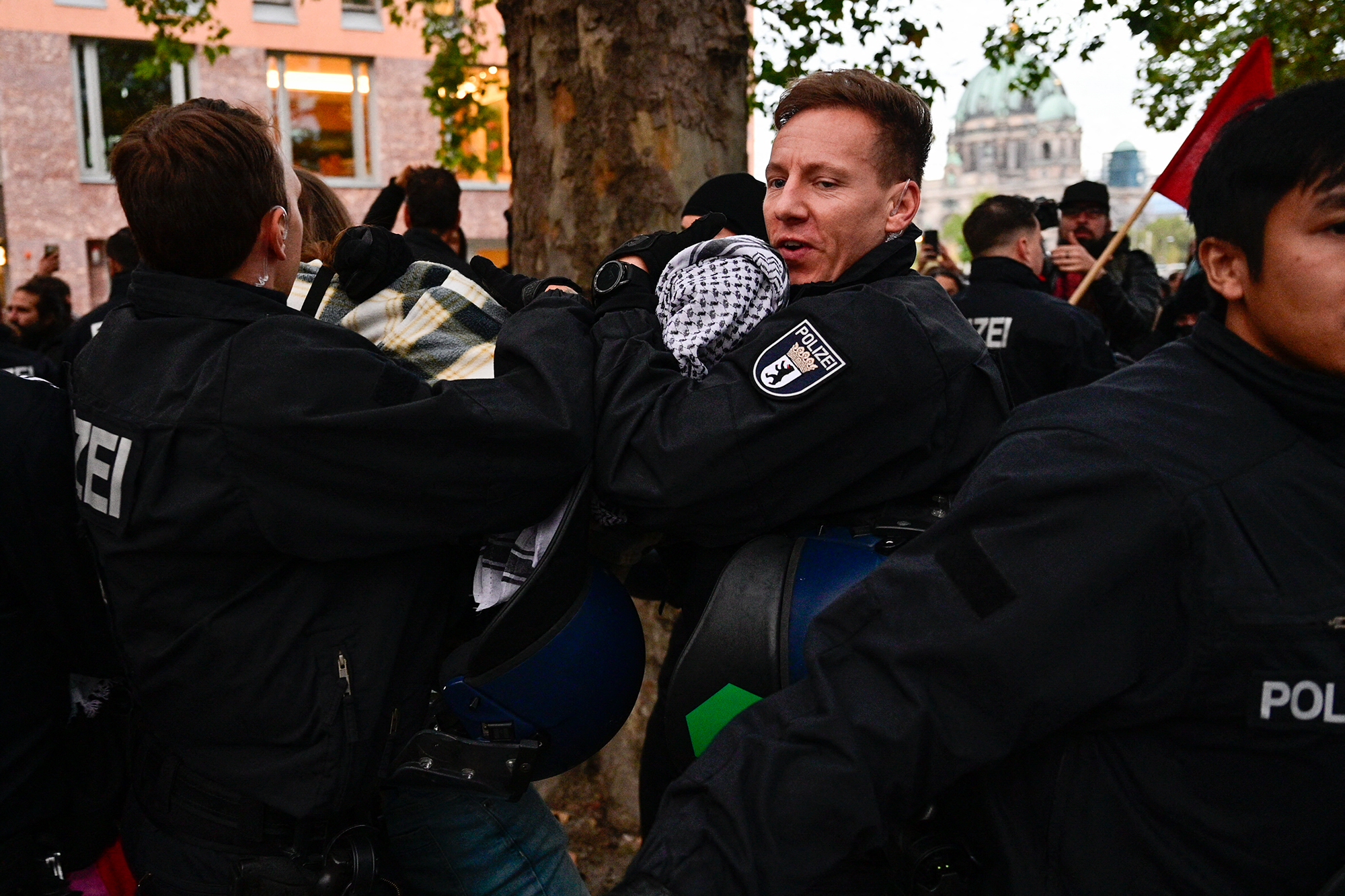 Berliner Polizisten tragen einen Demonstranten weg (Archivbild: John MacDougall/AFP)