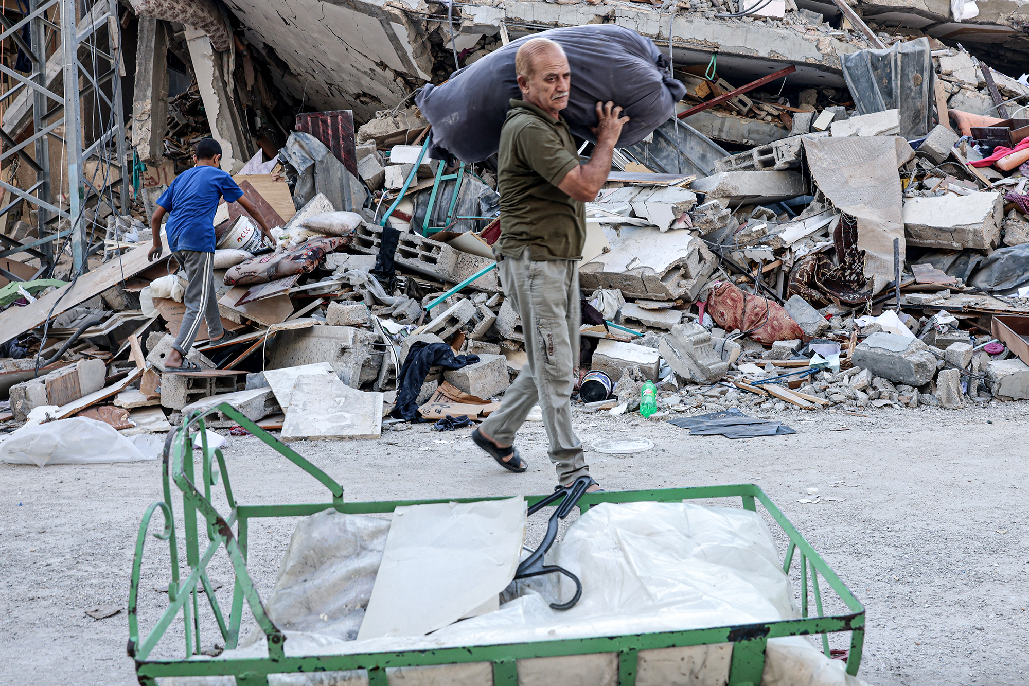 Palästinenser suchen in der Stadt Rafah im südlichen Gazastreifen nach brauchbaren Gegenständen nach der Zerstörung eines Gebäudes durch israelische Luftangriffe.