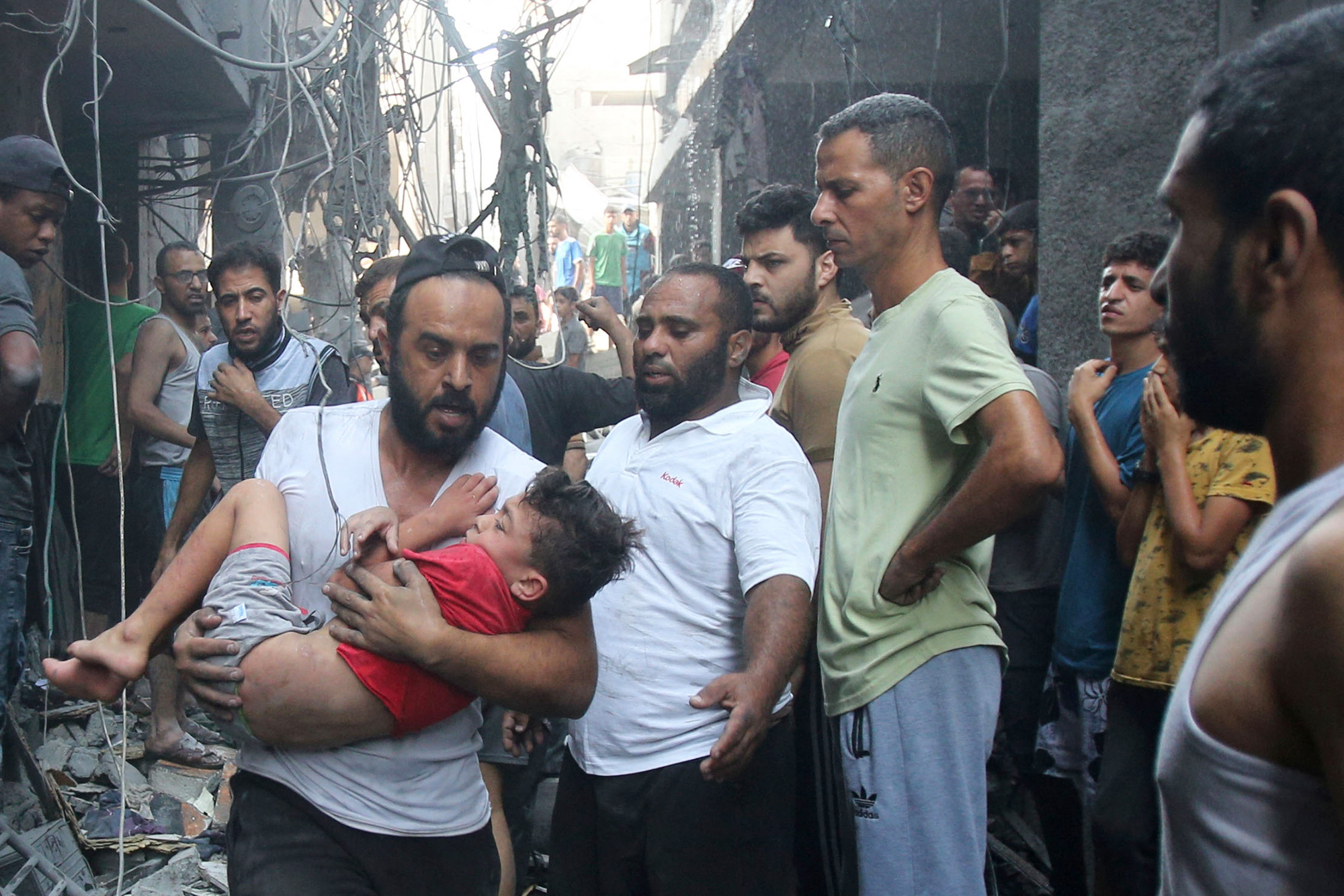 Ein Mann flieht mit einem Kind vor einem israelischen Luftangriff in Gaza-Stadt (Bild: Bashar Taleb/AFP)