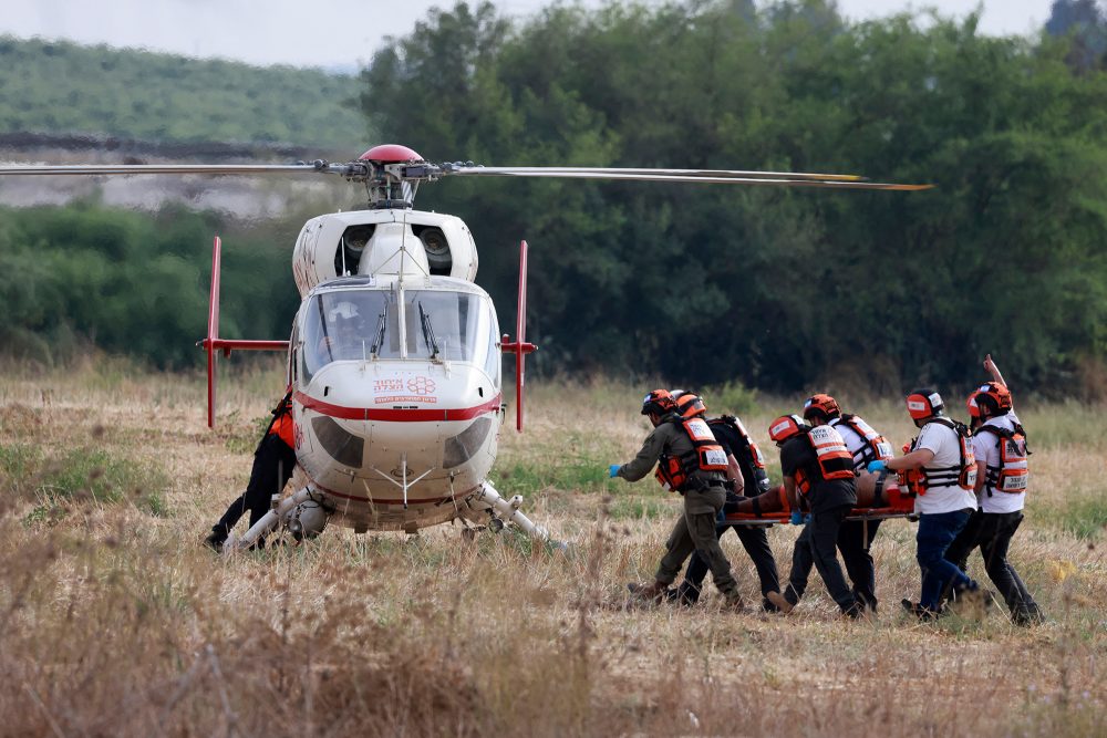 Israelische Rettungskräfte transportieren Opfer ins Krankenhaus (Bild: Menahem Kahana/AFP)