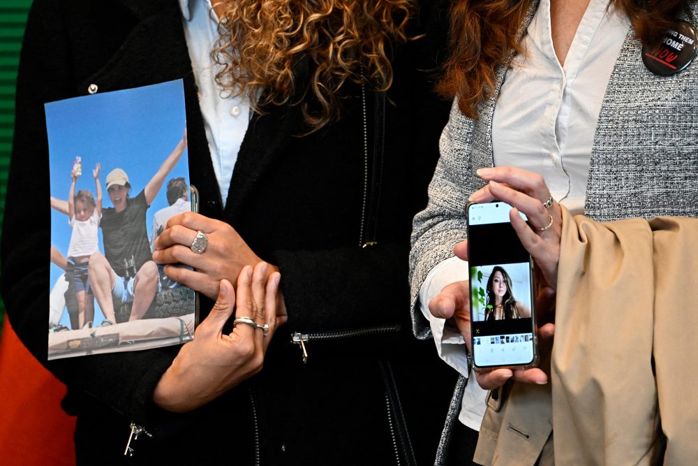 Verwandte mit Fotos von Shani Nicole Louk (Bild: Tobias Schwarz/AFP)