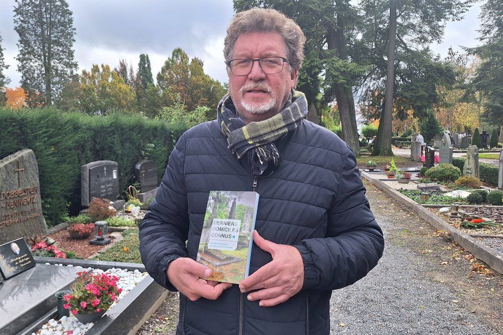 Thierry Luthers mit seinem Buch "Dernier Domiciles Connus" auf dem Eupener Friedhof (Bild: Gudrun Hunold/BRF)