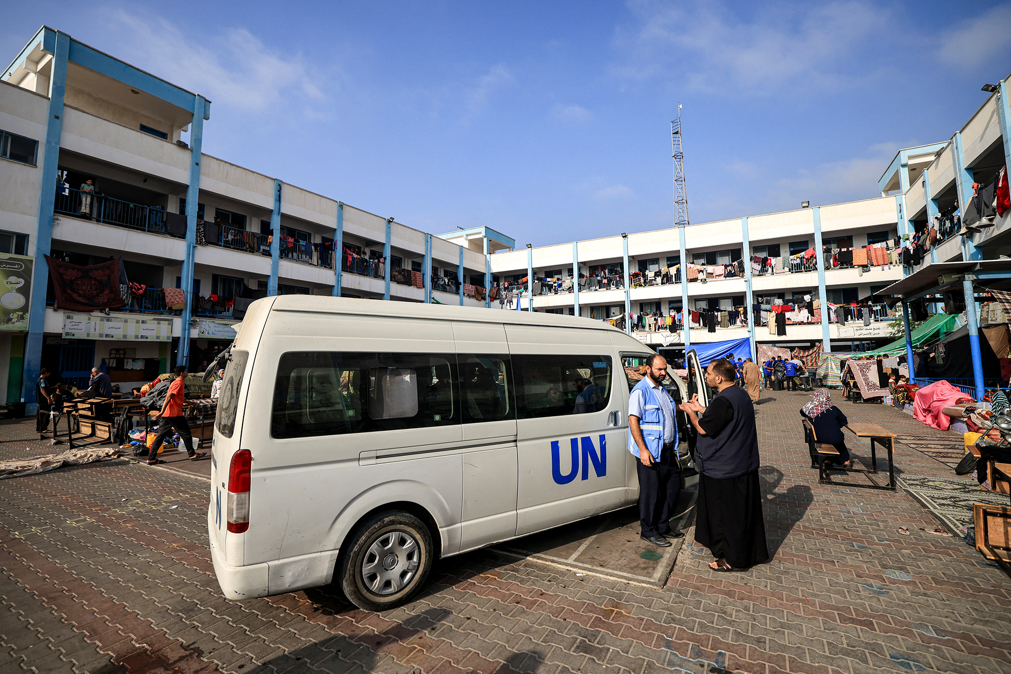Mitarbeiter des Hilfswerks der Vereinten Nationen für Palästinaflüchtlinge (UNRWA) vor einem ihrer Fahrzeuge im südlichen Gazastreifen (Archivbild: Mahmud Hams/AFP)