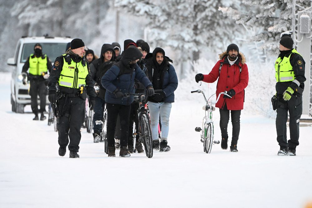 Finnische Grenzschützer mit Migranten am Grenzübergang Salla am Donnerstag (Bild: Jussi Nukari/Lehtikuva/AFP)