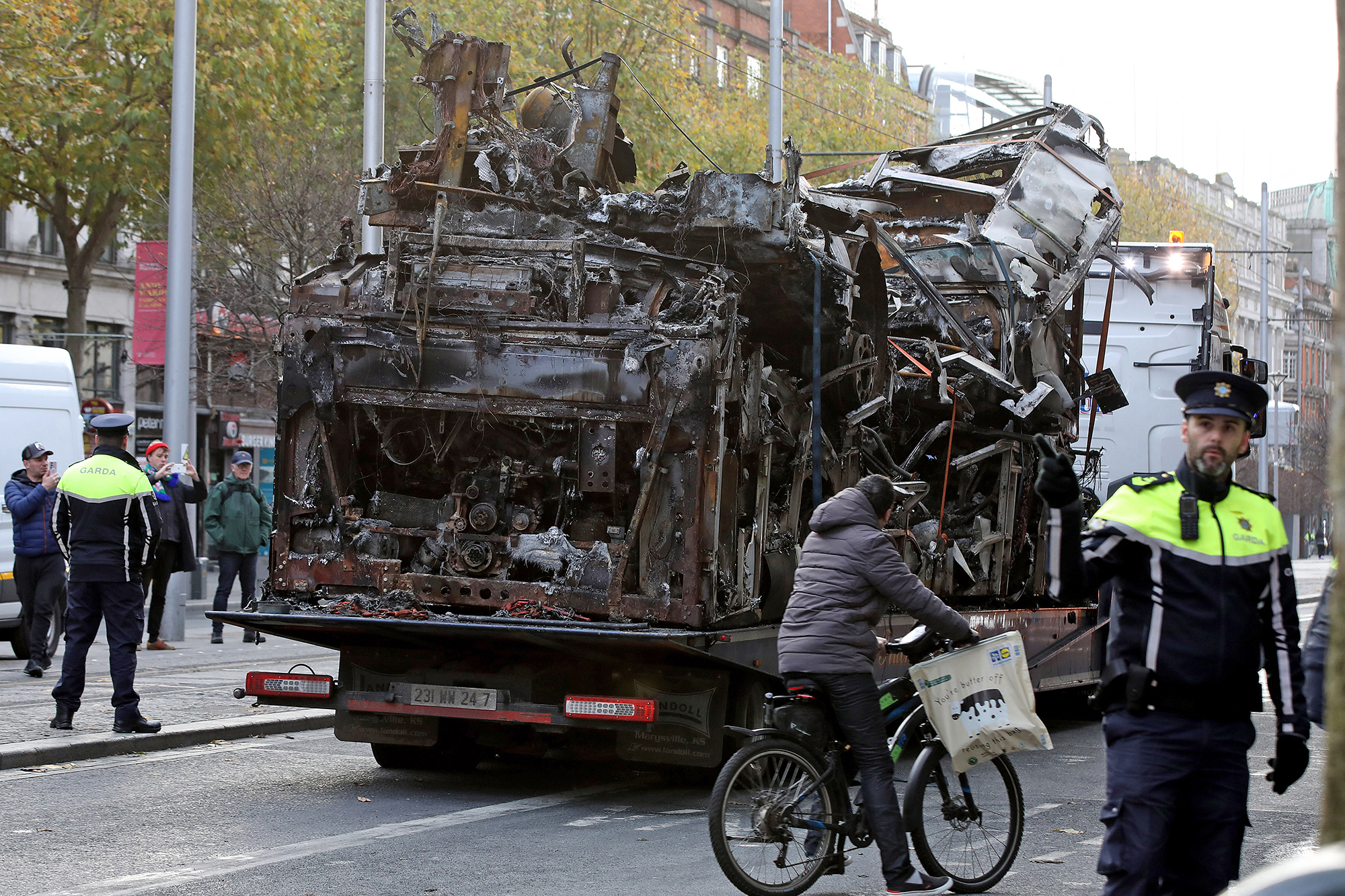 Das Wrack eines ausgebrannten Busses wird am Morgen danach abtransportiert (Bild: Paul Faith/AFP)