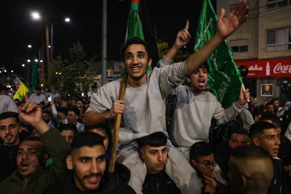 Feiernde Menschen mit grünen Fahnen der islamistischen Hamas (Bild: Ahmad Gharabli/AFP)