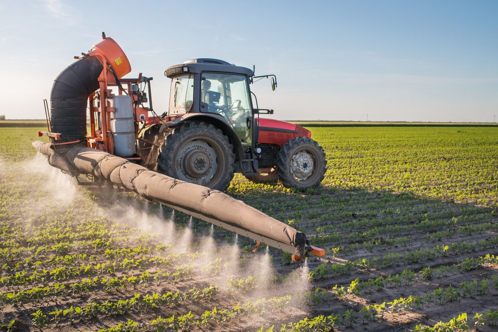 Traktor verteilt Pestizide auf einem Feld