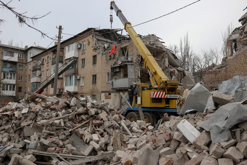 Ukrainische Rettungskräfte bergen mit einem Kran eine Leiche aus einem durch einen russischen Angriff schwer beschädigten Wohnhaus in der Stadt Selydowe in der Region Donezk (Bild: Anatolii Stepanov/AFP)