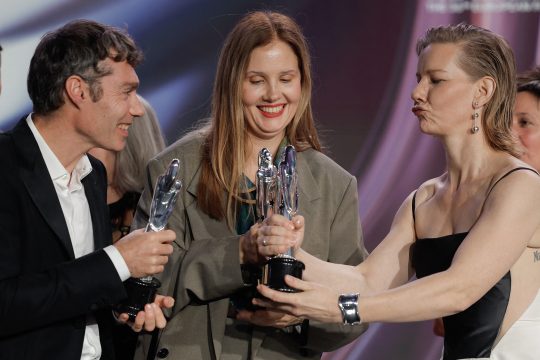 Die französische Regisseurin Justine Triet (Mi.) und die deutsche Schauspielerin Sandra Hüller mit einem weiteren Crew-Mitglied des Films "Anatomie eines Falls" bei der Verleihung des 36. Europäischen Filmpreises in Berlin (Bild: Odd Andersen/AFP)