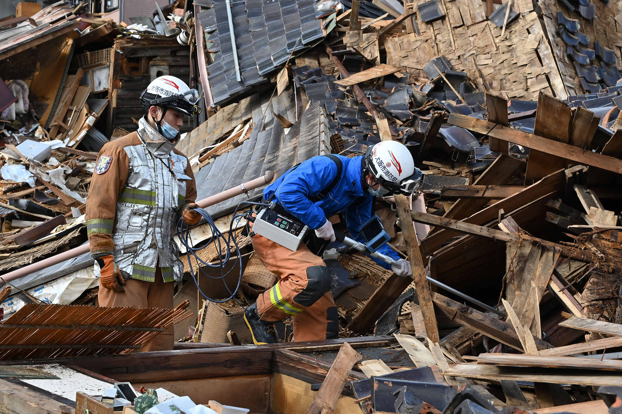 Rettungskräfte suchen in den Trümmern nach Überlebenden (Bild: Kazuhiro Nogi/AFP)