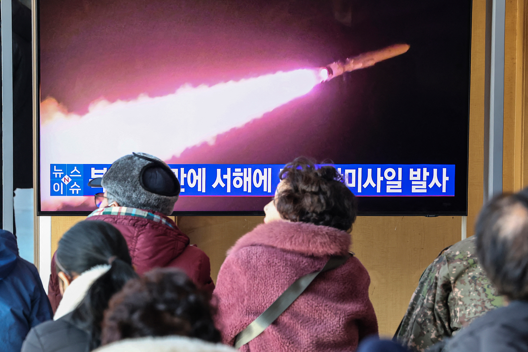 Passanten sehen auf einem Bildschirm in einem Bahnhof in Südkoreas Hauptstadt Seoul einen Bericht über einen erneuten nordkoreanischen Raketentest (Bild: Yonhap/AFP)