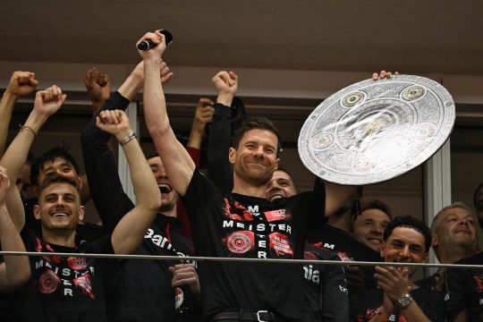 Bayer Leverkusens Trainer Xabi Alonso feiert mit seinen Spielern schon mal mit einer Attrappe der Meisterschale die nicht mehr zu nehmende Meisterschaft