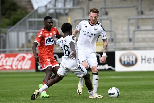 Kortrijk's Kings Kangwa and Eupen's Renaud Emond fight for the ball during a soccer match between KAS Eupen and KV Kortrijk, Sunday 07 April 2024 in Eupen, on the first day of the 2023-2024 'Jupiler Pro League - Relegation Play-offs. BELGA PHOTO JOHN THYS
