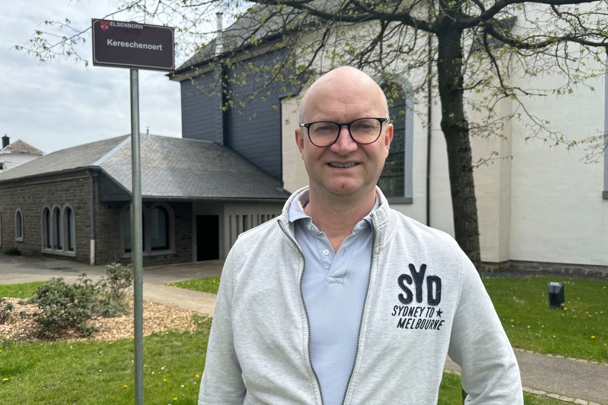 Bütgenbachs Bauschöffe Stéphan Noel vor dem "Kereschenoert"-Schild in Elsenborn 