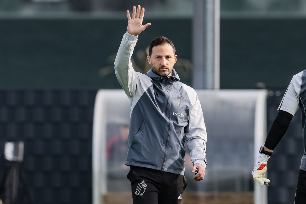 Domenico Tedesco steht am Spielfeldrand und hält winkend einen Arm in die Luft